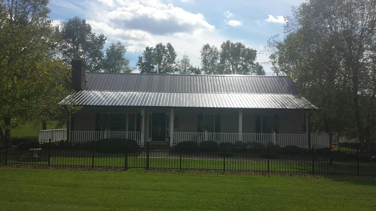Gray metal roof on a brick ranch with a full width front porch — Gutter Guard Installation work by our crew in Glen Rock